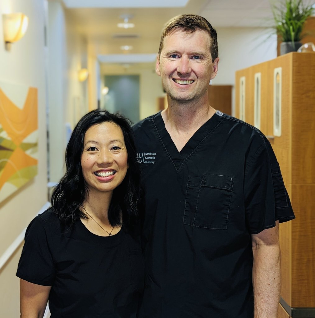 Both doctors posing in office hallway